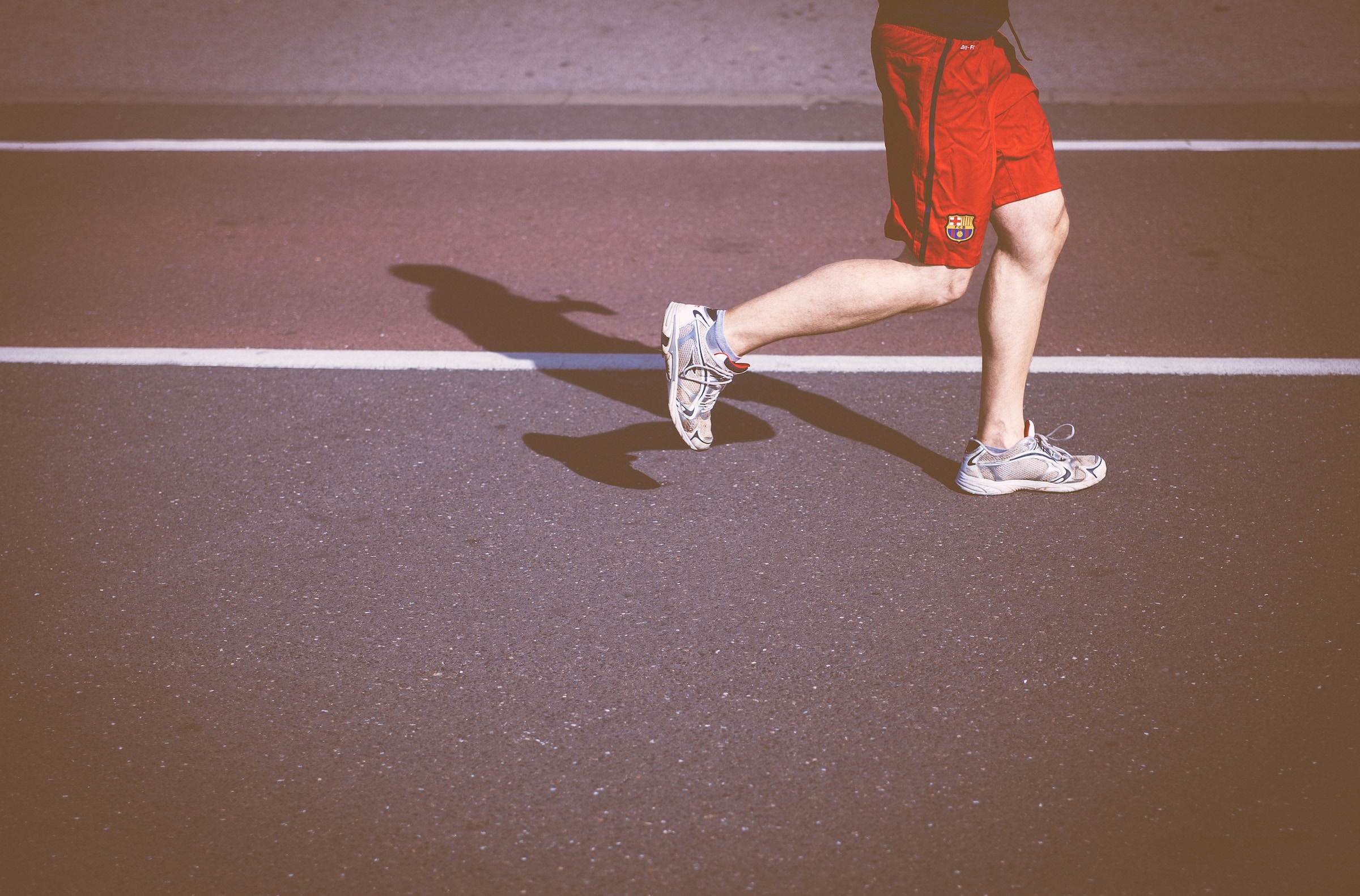 Man in red shorts running on a track